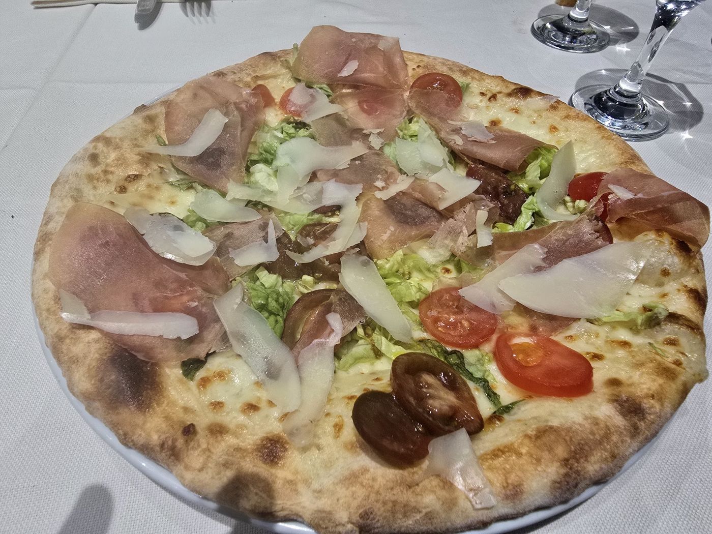 Pizza con crudo e scaglie di grana